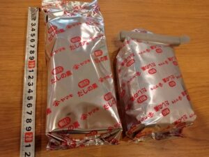 コストコのヤマキだしの素。500g入りの頑丈な銀色パックにメジャーを添えて、大きさを測っている写真。